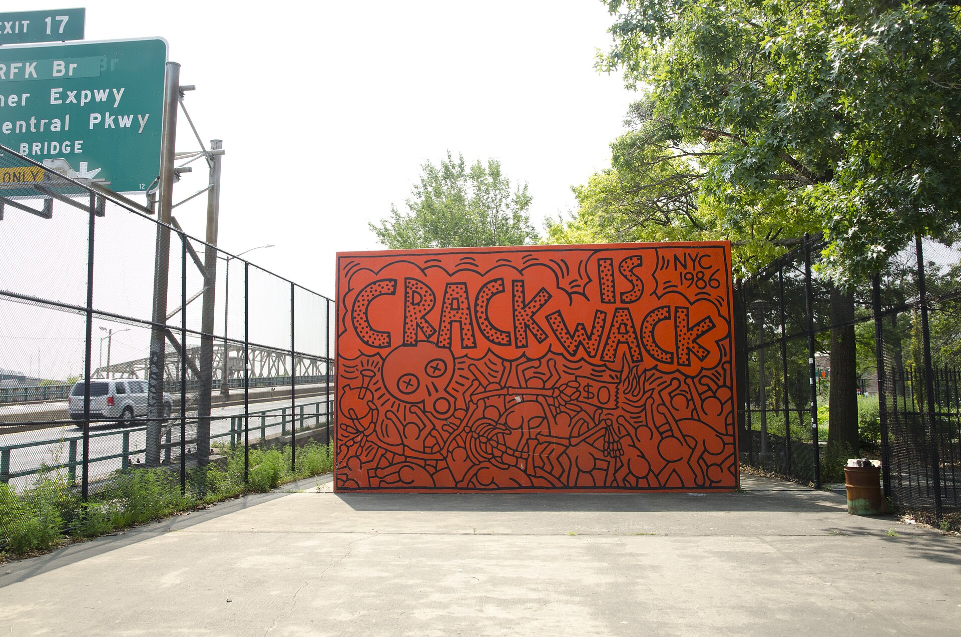 Crack is Wack — Keith Haring's orange mural covered in black figures and lettering, on a handball-court wall beside the Harlem River Drive