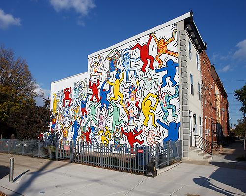 We The Youth — Keith Haring's bold red, yellow, and blue dancing figures covering the side of a Point Breeze rowhome